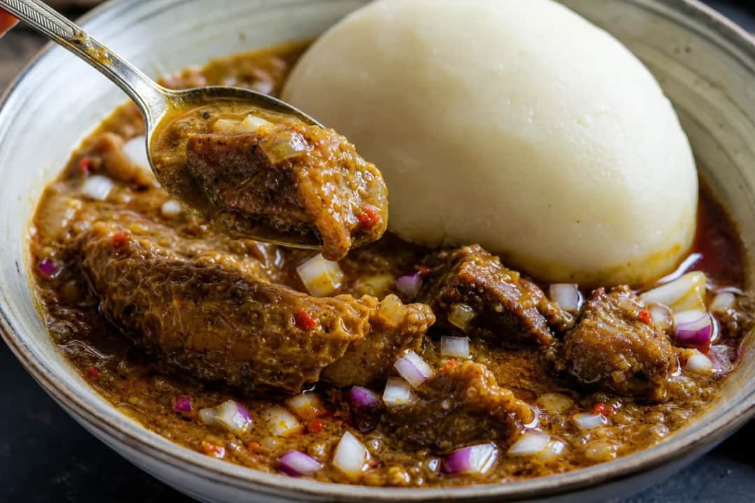 A bowl of Nigerian Ogbono soup with pounded yam, showcasing a rich, thick texture and vibrant colors.