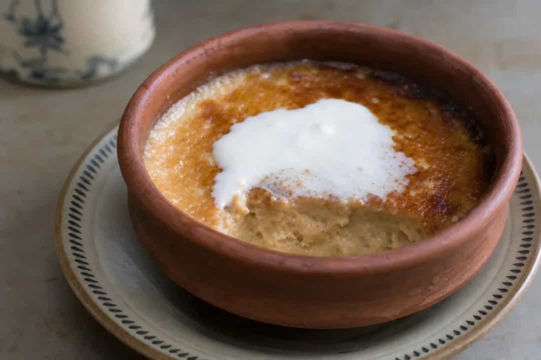 Creamy Mishti Doi topped with caramel, served in a decorative bowl with a smooth texture.