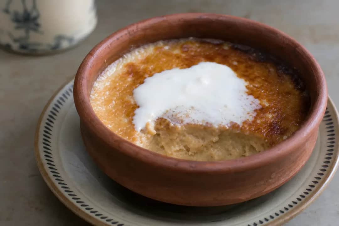 Creamy Mishti Doi topped with caramel, served in a decorative bowl with a smooth texture.