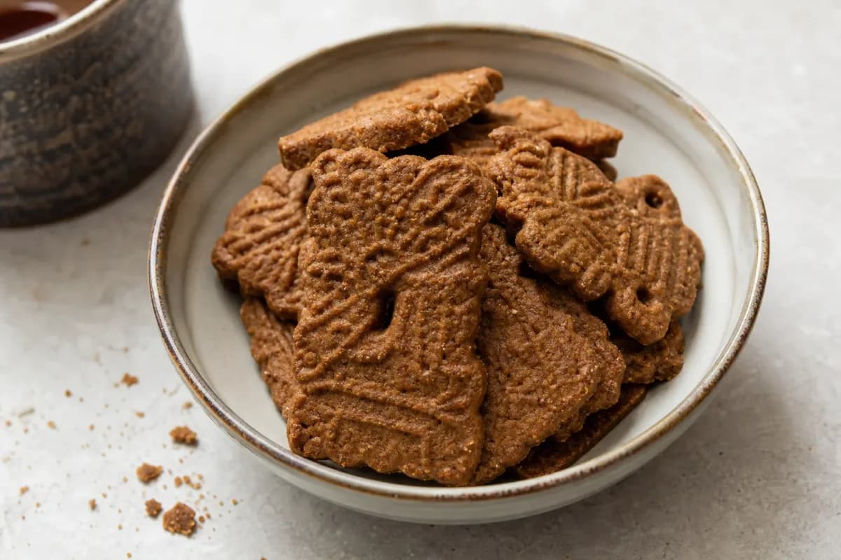 Golden-brown speculoos cookies with a spiced surface, arranged on a plate.