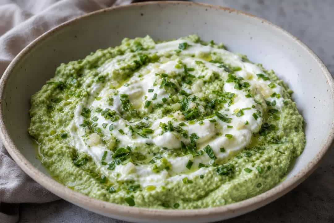 Creamy green goddess dip with vibrant herbs, served with fresh veggies and crispy crackers.