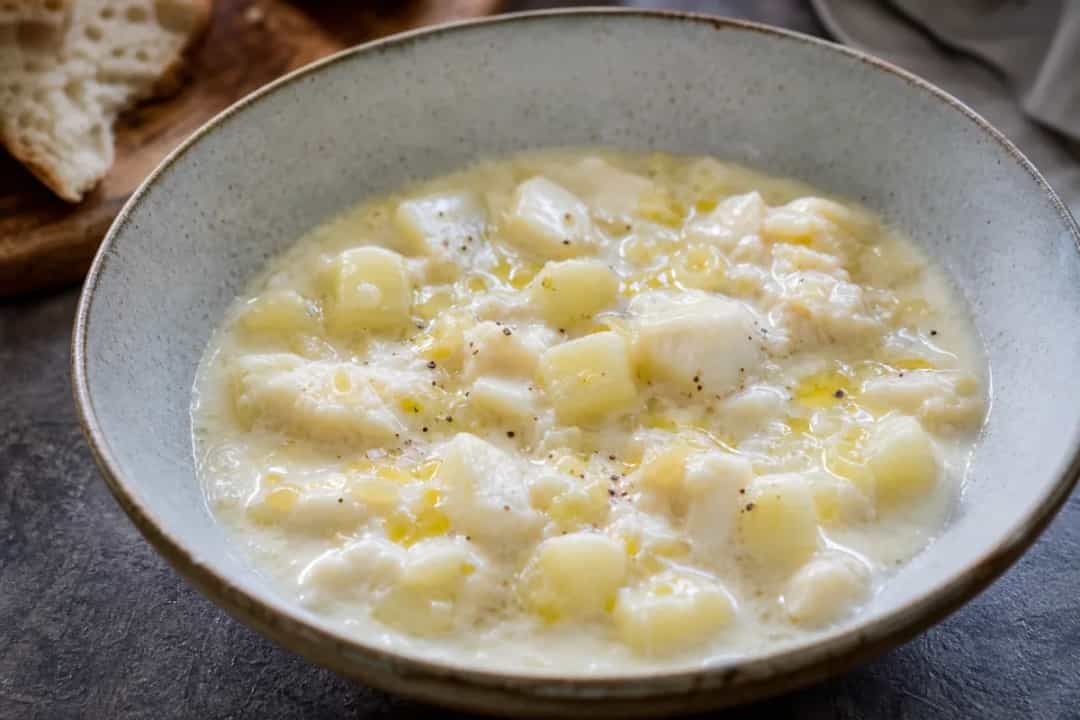 Creamy seafood chowder garnished with fresh herbs and served in a bowl.