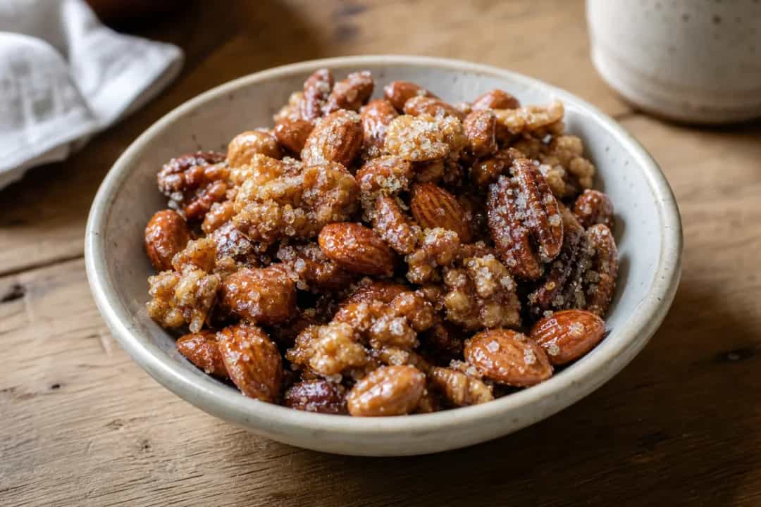 Plated dessert featuring crunchy caramelized nuts atop a creamy base, garnished elegantly.