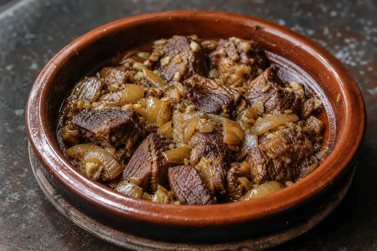 Tender lamb pieces in a rich sauce with prunes and almonds, garnished with herbs.