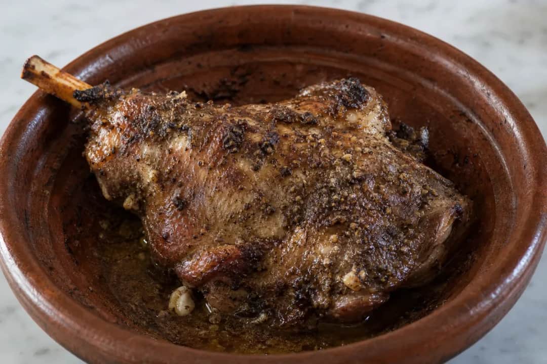 Tender roasted lamb with a golden crust, garnished with cumin and sea salt.