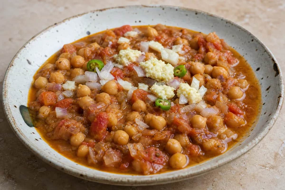 A hearty bowl of chana masala with chickpeas and spices, garnished with fresh cilantro.