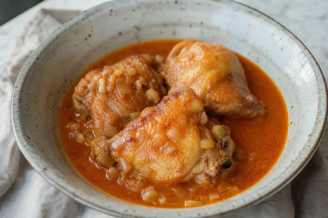 Creamy chicken paprikash served with a sprinkle of parsley over rice, showcasing a rich sauce and tender chicken.